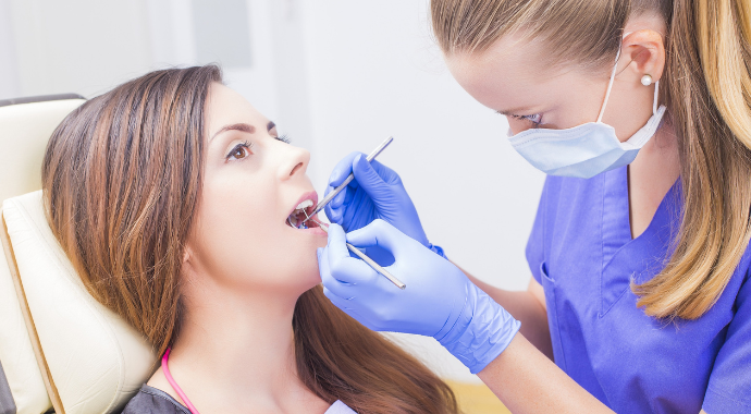 Woman in Dental Chair getting laser dentistry treatment from dental assistant